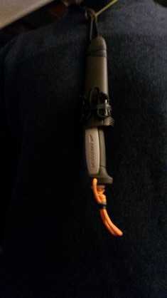 en mode cou, fixé à une paracorde facilement "demontable" fin qu'elle ne gène pas lors du port à la ceinture<br />et la dragonne pliée (chambre a air)  afin qu'elle gêne pas lors du port en "cou"<br />Trés IMPORTANT, afin d'améliorer la rétention du couteau, il suffit simplement de l'introduire dans l'étui en sens inverse et çà marche !